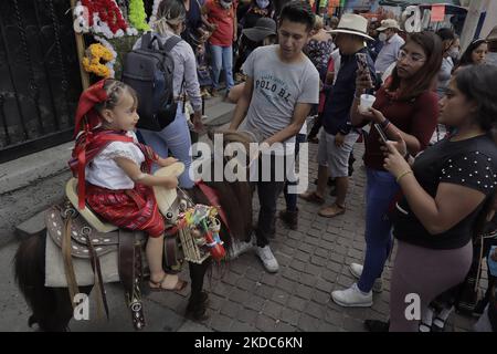 Une fille passe un âne devant l'église du Seigneur du Calvaire à Mexico, à l'occasion du jeudi Corpus Christi, mieux connu sous le nom de « Day of the Mules ». Selon la foi, les filles et les garçons sont vêtus de costumes indigènes en commémoration de Juan Diego, considéré comme le « archétype et symbole des chrétiens autochtones d'antan ». Les enfants sont également emmenés à l'église pour recevoir une bénédiction. (Photo de Gerardo Vieyra/NurPhoto) Banque D'Images