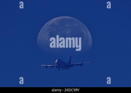 (NOTE DE LA RÉDACTION: Plusieurs expositions ont été combinées dans la caméra pour produire cette image) Un avion commercial fait une descente vers l'aéroport international de Changi alors que la lune se prépare sur 19 juin 2022 à Singapour. (Photo de Suhaimi Abdullah/NurPhoto) Banque D'Images