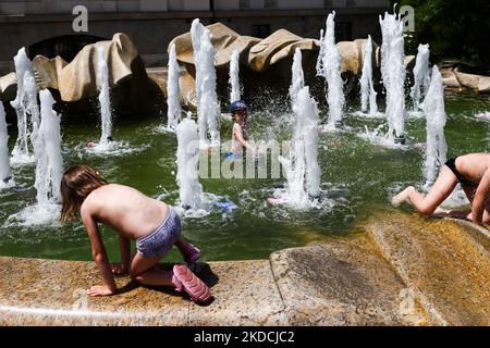 Les enfants s'amusent dans une fontaine de la place Szczepanski à Cracovie, en Pologne, sur 19 juin 2022. Les masses d'air chaud de toute l'Afrique couvraient la plus grande partie du pays. (Photo de Beata Zawrzel/NurPhoto) Banque D'Images