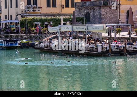 Peschiera del Garda, Vérone, Italie - 22 septembre 2022 personnes qui apprécient de manger sur une terrasse d'un restaurant flottant avec une belle vue sur Peschiera Banque D'Images