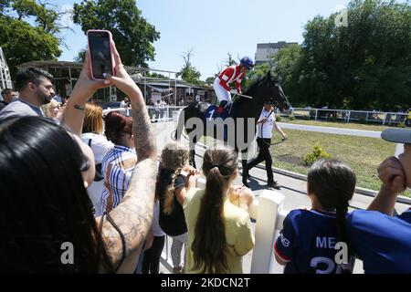 Les Ukrainiens regardent les cavaliers avec des chevaux pendant une saison d'ouverture d'été de horserace, dans le cadre de l'invasion de l'Ukraine par la Russie, à l'hippodrome d'Odesa, Ukraine le 25 juin 2022. (Photo par STR/NurPhoto) Banque D'Images