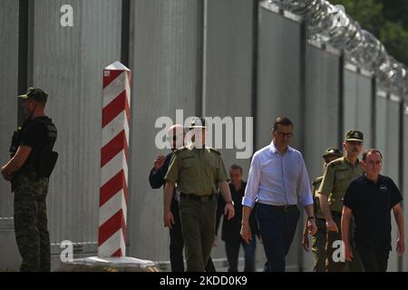 Le Premier ministre Mateusz Morawiecki (au centre) est apparu à la frontière entre la Pologne et la Biélorussie, au mur de la frontière, que le gouvernement polonais a appelé une « barrière physique ». Il a participé à la remise de cette structure en acier et en béton à la Garde frontalière, par l'entrepreneur du projet, les sociétés Budimex, Unibep et Budrex. Le mur frontalier de la frontière entre la Pologne et le Bélarus a été construit avec 50 000 tonnes d'acier. Elle mesure 5,5 mètres de haut, surmontée d'un fil de rasoir et s'étend sur 186,25 km. Jeudi, 30 juin 2022, à Nowodziel, près de Kuznica, Podlaskie Voivodeship, Pologne. (Photo par Artu Banque D'Images