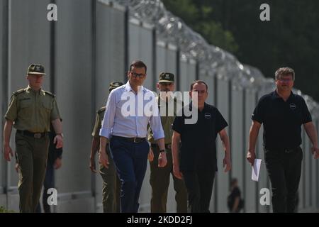 (G-D) Brigadier général Grzegorz Niemiec, commandant en chef adjoint de la Garde frontalière, général de brigade Wioleta Gorzkowska, (vue partielle) commandant en chef adjoint de la Garde frontalière, Mateusz Morawiecki, Premier ministre de Pologne, général de division Tomasz Praga, commandant en chef de la Garde frontalière, Mariusz Kami ski, Ministre de l'intérieur et de l'administration et Maciej Wasik, secrétaire d'État au ministère de l'intérieur et de l'administration, marchant près de la nouvelle clôture à la frontière entre la Pologne et le Bélarus, près du village de Nowdziel. Le Premier ministre Mateusz Morawiecki (Centre) a comparu sur le poli Banque D'Images