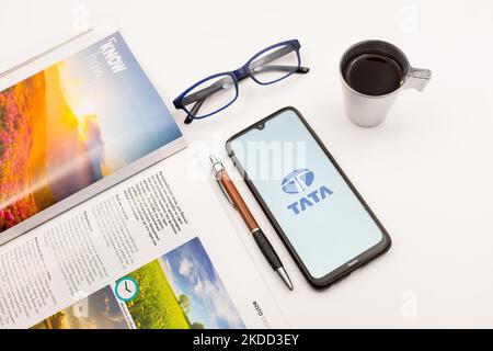 Sur cette photo, un logo Tata Motors apparaît sur l'écran d'un smartphone, sur un bureau à côté d'un café, d'un stylo, de lunettes et d'un magazine à Athènes, en Grèce, sur 2 juillet 2022. (Photo d'illustration par Nikolas Kokovlis/NurPhoto) Banque D'Images