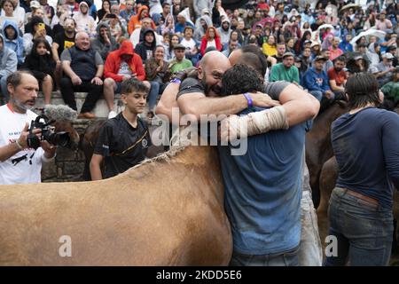 ''Rapa das Bestas''. Chaque année depuis le XVIIe siècle, dans la petite ville de Sabucedo, ''aloitadores'' coupe les manes des chevaux sauvages. Les gens de Sabucedo vont dans les montagnes près de la ville pour capturer les chevaux et les ramener pour célébrer cette tradition. Quand ils ont fini la coupe des manes, ils ont libéré de nouveau les chevaux dans les montagnes, à Sabucedo, Galice, Espagne, sur 3 juillet, 2022. Banque D'Images