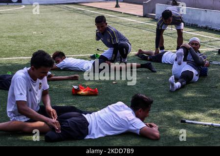 Les joueurs de Garuda Indonesia Amputee football (Garuda INAF) font des exercices d'étirement lors d'une session d'entraînement à Jakarta, Indonésie sur 5 juillet 2022. L'équipe indonésienne de football amputé est composée de joueurs qui ont tous perdu des bras ou des jambes lors de différents accidents dans le pays, compte environ 20 joueurs et s'est qualifiée pour la coupe du monde de football Amputee qui se tiendra à Istanbul, en Turquie, en octobre 2022. (Photo de Garry Lotulung/NurPhoto) Banque D'Images