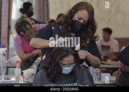 Une femme du Barrio San Juan del Pueblo San Francisco Culhuacán, à Mexico, coupe gratuitement les cheveux d'une personne, dans le cadre des activités organisées par des femmes voisines dans la région en collaboration avec les autorités de la capitale. Selon les données de l'Institut national de statistique et de géographie (INEGI), la majorité des travailleuses autonomes travaillent dans le secteur tertiaire (81,2%) dans le commerce, les restaurants et divers services tels que la coiffure, la cosmétologie et les salons de beauté. (Photo de Gerardo Vieyra/NurPhoto) Banque D'Images