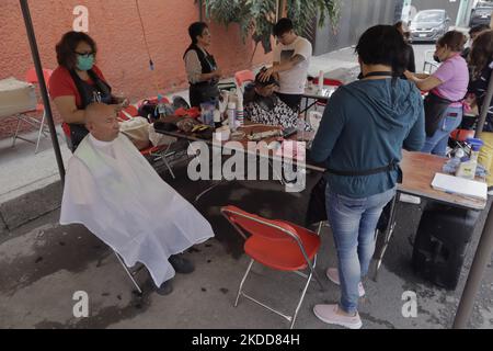 Les femmes du quartier San Juan de San Francisco Culhuacán à Mexico ont coupé les cheveux gratuitement pour les voisins et les passants, dans le cadre des activités organisées par les femmes de la région en collaboration avec les autorités de la capitale. Selon les données de l'Institut national de statistique et de géographie (INEGI), la majorité des travailleuses autonomes travaillent dans le secteur tertiaire (81,2%) dans le commerce, les restaurants et divers services tels que la coiffure, la cosmétologie et les salons de beauté. (Photo de Gerardo Vieyra/NurPhoto) Banque D'Images