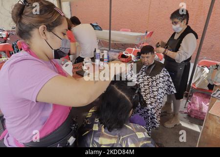 Une femme du Barrio San Juan del Pueblo San Francisco Culhuacán, à Mexico, coupe gratuitement les cheveux d'une personne, dans le cadre des activités organisées par des femmes voisines dans la région en collaboration avec les autorités de la capitale. Selon les données de l'Institut national de statistique et de géographie (INEGI), la majorité des travailleuses autonomes travaillent dans le secteur tertiaire (81,2%) dans le commerce, les restaurants et divers services tels que la coiffure, la cosmétologie et les salons de beauté. (Photo de Gerardo Vieyra/NurPhoto) Banque D'Images