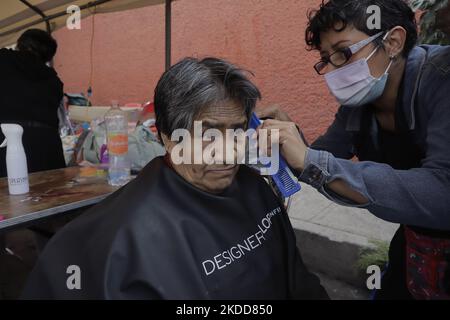 Une femme du Barrio San Juan del Pueblo San Francisco Culhuacán, à Mexico, coupe gratuitement les cheveux d'une personne, dans le cadre des activités organisées par des femmes voisines dans la région en collaboration avec les autorités de la capitale. Selon les données de l'Institut national de statistique et de géographie (INEGI), la majorité des travailleuses autonomes travaillent dans le secteur tertiaire (81,2%) dans le commerce, les restaurants et divers services tels que la coiffure, la cosmétologie et les salons de beauté. (Photo de Gerardo Vieyra/NurPhoto) Banque D'Images