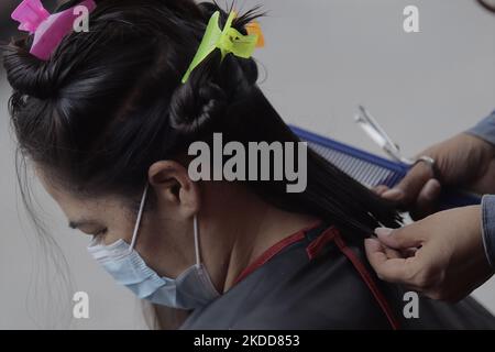 Une personne de Barrio San Juan del Pueblo San Francisco Culhuacán à Mexico City obtient sa coupe de cheveux gratuitement dans le cadre d'activités organisées par des femmes dans la région en collaboration avec les autorités de Mexico. Selon les données de l'Institut national de statistique et de géographie (INEGI), la majorité des travailleuses autonomes travaillent dans le secteur tertiaire (81,2%) dans le commerce, les restaurants et divers services tels que la coiffure, la cosmétologie et les salons de beauté. (Photo de Gerardo Vieyra/NurPhoto) Banque D'Images