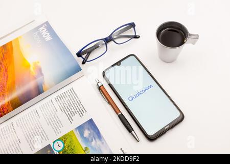 Sur cette photo, un logo Qualcomm apparaît sur l'écran d'un smartphone, sur un bureau à côté d'un café, d'un stylo, de lunettes et d'un magazine à Athènes, en Grèce, sur 7 juillet 2022. (Photo d'illustration par Nikolas Kokovlis/NurPhoto) Banque D'Images