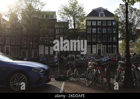 Un homme écoute de la musique avec des écouteurs tout en pêchant sur un canal à Amsterdam. Pays-Bas, vendredi, 8 juillet 2022. (Photo de Danil Shamkin/NurPhoto) Banque D'Images
