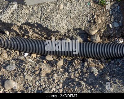 Tuyau de communication souterrain. Tube élastique noir pour fils. Travaux de réparation. Banque D'Images