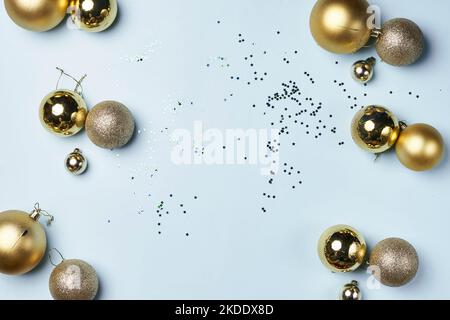 quelques boules de noël en or et confes sur un fond blanc avec la confiserie au milieu Banque D'Images