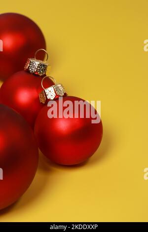 Boules décoratives de Noël rouges sur fond jaune. Flat lay, vue de dessus, espace de copie Banque D'Images