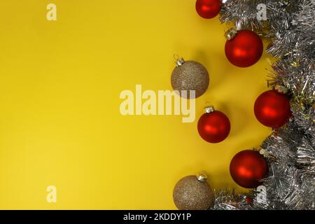 Boules décoratives de Noël rouges et dorées sur fond jaune. Flat lay, vue de dessus, espace de copie Banque D'Images