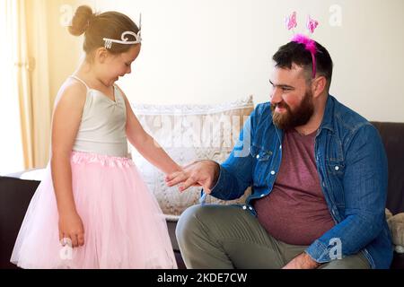 Une adorable petite fille qui peint ses ongles de pères à la maison. Banque D'Images