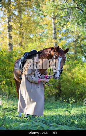 Beauté modèle de mode avec un cheval dans la forêt d'automne Banque D'Images