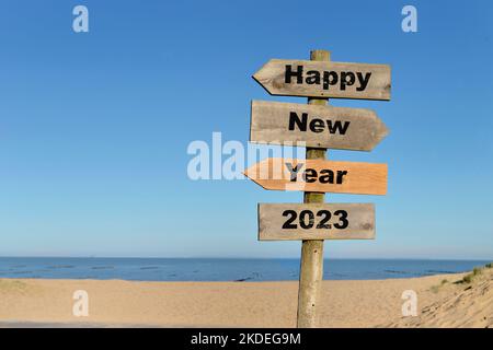 2023 bonne année écrite sur un panneau de direction en face d'une plage sur ciel bleu Banque D'Images