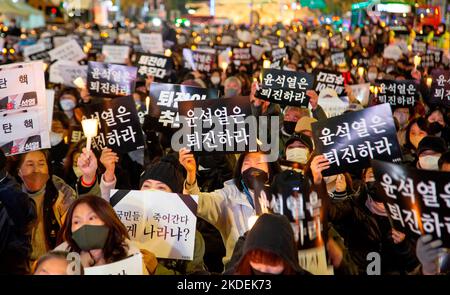 Les gens pleurent pour les victimes de l'écrasement de la foule d'Halloween, 5 novembre 2022 : les gens participent à une veillée aux chandelles organisée pour pleurer les victimes de l'écrasement de la foule d'Halloween à Séoul, Corée du Sud. Des milliers de personnes ont demandé la démission du président sud-coréen Yoon Suk-Yeol pour assumer sa responsabilité dans la catastrophe du district d'Itaewon où la foule d'Halloween a tué 156 personnes et en a blessé 197. Les lettres coréennes sur les piquetage ont lu, "Yoon Suk-Yeol démissionnent", "la démission de Yoon Suk-Yeol est le souvenir (pour les victimes)" et "(Yoon Suk-Yeol) résignation est la paix (betwe Banque D'Images