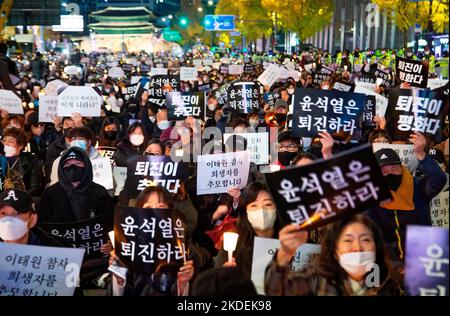 Les gens pleurent pour les victimes de l'écrasement de la foule d'Halloween, 5 novembre 2022 : les gens participent à une veillée aux chandelles organisée pour pleurer les victimes de l'écrasement de la foule d'Halloween à Séoul, Corée du Sud. Des milliers de personnes ont demandé la démission du président sud-coréen Yoon Suk-Yeol pour assumer sa responsabilité dans la catastrophe du district d'Itaewon où la foule d'Halloween a tué 156 personnes et en a blessé 197. Les lettres coréennes sur les piquetage ont lu, "Yoon Suk-Yeol démissionnent", "la démission de Yoon Suk-Yeol est le souvenir (pour les victimes)" et "(Yoon Suk-Yeol) résignation est la paix (betwe Banque D'Images