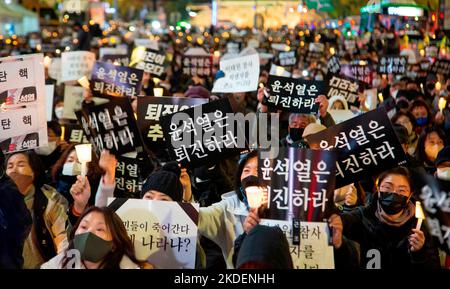 Les gens pleurent pour les victimes de l'écrasement de la foule d'Halloween, 5 novembre 2022 : les gens participent à une veillée aux chandelles organisée pour pleurer les victimes de l'écrasement de la foule d'Halloween à Séoul, Corée du Sud. Des milliers de personnes ont demandé la démission du président sud-coréen Yoon Suk-Yeol pour assumer sa responsabilité dans la catastrophe du district d'Itaewon où la foule d'Halloween a tué 156 personnes et en a blessé 197. Les lettres coréennes sur les piquetage ont lu, "Yoon Suk-Yeol démissionnent", "la démission de Yoon Suk-Yeol est le souvenir (pour les victimes)" et "(Yoon Suk-Yeol) résignation est la paix (betwe Banque D'Images