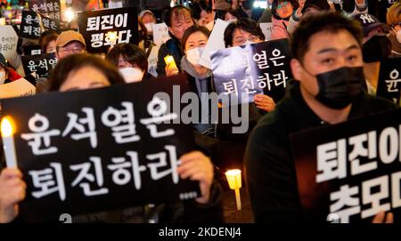 Les gens pleurent pour les victimes de l'écrasement de la foule d'Halloween, 5 novembre 2022 : les gens participent à une veillée aux chandelles organisée pour pleurer les victimes de l'écrasement de la foule d'Halloween à Séoul, Corée du Sud. Des milliers de personnes ont demandé la démission du président sud-coréen Yoon Suk-Yeol pour assumer sa responsabilité dans la catastrophe du district d'Itaewon où la foule d'Halloween a tué 156 personnes et en a blessé 197. Les lettres coréennes sur les piquetage ont lu, "Yoon Suk-Yeol démissionnent", "la démission de Yoon Suk-Yeol est le souvenir (pour les victimes)" et "(Yoon Suk-Yeol) résignation est la paix (betwe Banque D'Images