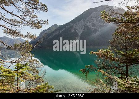 Lac de Plansee et montagne en arrière-plan lors d'une journée d'automne ensoleillée dans les Alpes d'Ammergau, Tyrol, Autriche Banque D'Images