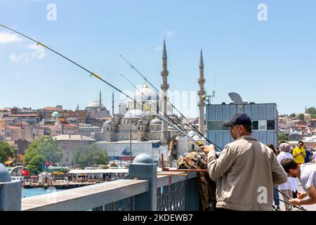 Pêcheurs locaux avec leurs lignes de pêche, sur le pont de Galata à Istanbul, Turquie. À l'arrière-plan, on peut voir la célèbre Mosquée bleue. Banque D'Images