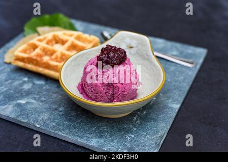 Crème glacée bio Hibiscus avec gaufres sur plaque de pierre avec cuillère et fourchette Banque D'Images