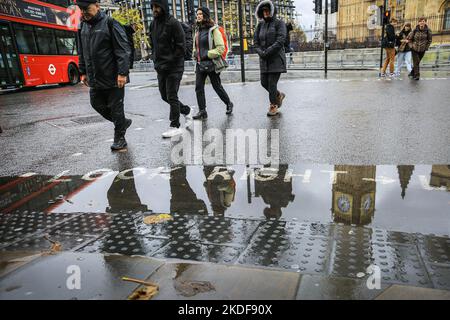 Londres, Royaume-Uni. 06th novembre 2022. Big Ben et le Parlement se reflètent dans des flaques sur la place du Parlement tandis que les gens marchent par temps pluvieux. Credit: Imagetraceur/Alamy Live News Banque D'Images