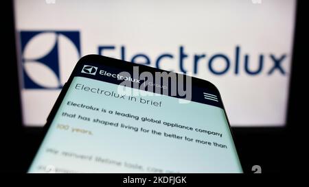Smartphone avec la page Web de la société suédoise d'appareils électroménagers Electrolux AB à l'écran devant le logo de l'entreprise. Mise au point sur l'affichage du téléphone. Banque D'Images