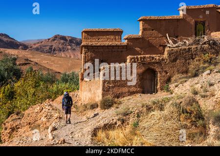 Jeune homme trekker près du village berbère de Tamgallouna dans la vallée des Roses sur le Trek gorge m'Goun dans les montagnes de l'Atlas du Maroc Banque D'Images