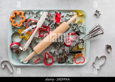 Une feuille de biscuit remplie de biscuit coupeurs et d'autres divers outils de cuisson. Banque D'Images