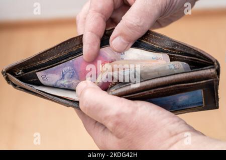 Gros plan des mains d'un homme comptant les factures d'un portefeuille. Concept finance, affaires, investissements, inflation. Banque D'Images