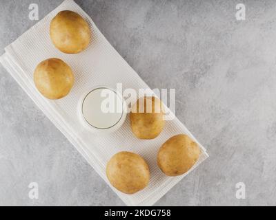 Lait de pomme de terre boisson non laitière de remplacement. Lait sans lactose et pommes de terre crues sur fond gris. Concept de lait alternatif Banque D'Images