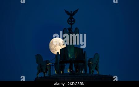 Berlin, Allemagne. 06th novembre 2022. La lune s'élève derrière la Quadriga sur la porte de Brandebourg. Credit: Paul Zinken/dpa/Alay Live News Banque D'Images