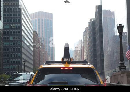 Manhattan, New York Canyon de gratte-ciels rue derrière un taxi jaune Banque D'Images