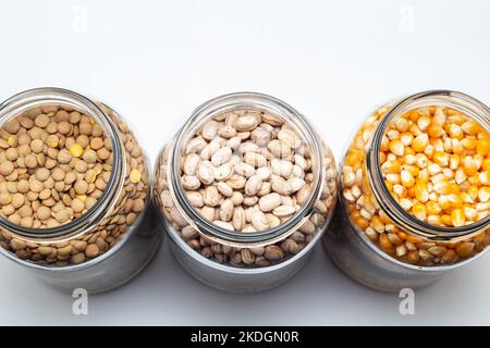 Goias, Brésil – 06 novembre 2022 : haricots, cornes et lentilles à l'intérieur de pots en verre sur une surface de couleur blanche. Banque D'Images