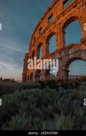 Magnifique colisée romain ou amphitéatre à Pula, lors d'une soirée d'été ensoleillée avec une atmosphère romantique. Détails parties de la belle structure romaine en or Banque D'Images