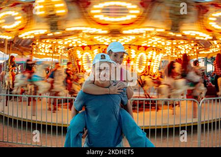 les adolescents qui courent devant un carrousel en mouvement Banque D'Images