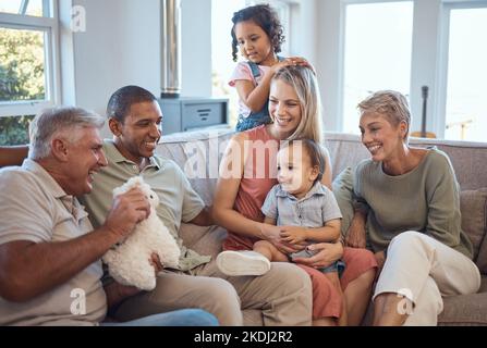 Enfants, amour et famille heureuse sur le canapé avec bébé, rire et jouer dans le salon dans leur maison. Interracial, famille heureuse et grands-parents, parents Banque D'Images