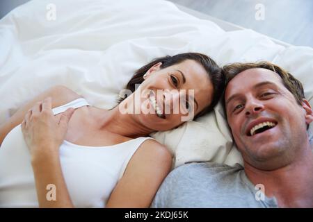 Se réveiller à côté de mon un et seulement. Portrait d'un couple mûr se relaxant au lit ensemble. Banque D'Images