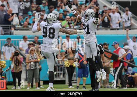 Samedi, 6 novembre 2022 ; Jacksonville, Floride, États-Unis ; Las Vegas Raiders défensive End Maxx Crosby (98) et le cornerback Amik Robertson (21) célèbrent l'arrêt Banque D'Images