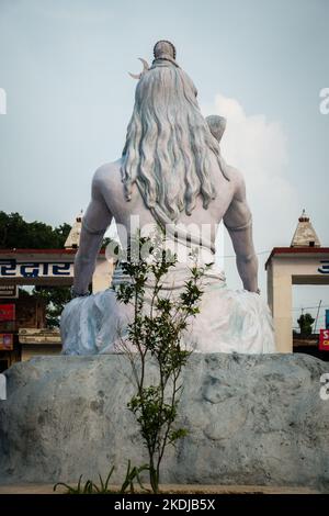 4 juillet 2022 Haridwar Inde. Statue de Lord Shiva à la gare de Haridwar avec des gens assis tout autour dans l'attente. Banque D'Images