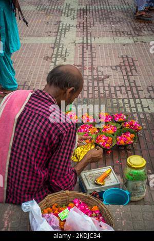 8 juillet 2022 Haridwar Inde. Un homme qui vend des fleurs colorées sur les rives ou les ghats de la rivière Ganges pour les rituels hindous. Banque D'Images