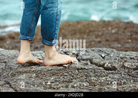 femme marchant pieds nus en bord de mer tenant les mains blanches chaussures. vacances d'été Banque D'Images