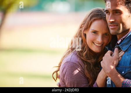 Tomber amoureux est le sentiment le plus beau. Un jeune couple souriant appréciant la journée ensemble au parc. Banque D'Images