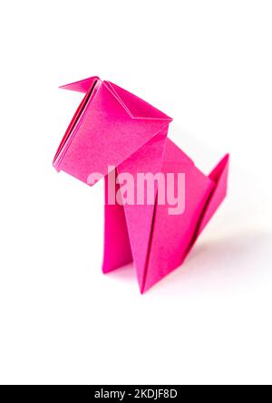 Chien en papier rose origami isolé sur un fond blanc vierge. Banque D'Images